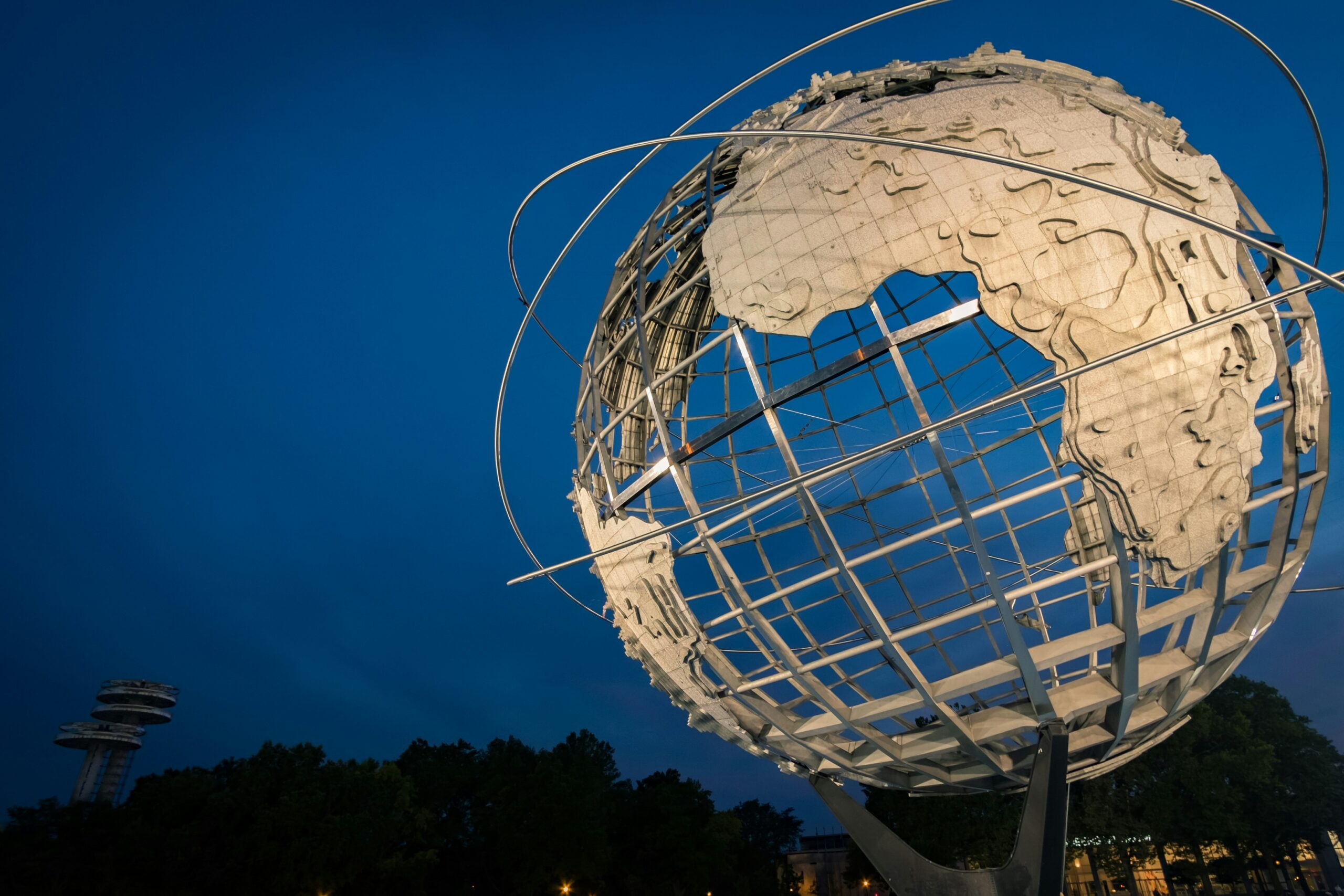 Photo of an outdoor sculpture of a large globe indicating lines of latitude and topography features of the Earth. (From Unsplash.)